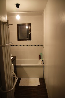 Photo du sol tout neuf, et de la lampe, reste Ã  poser une planche bois vernis Ã  la place de la blanche le long de la baignoire.