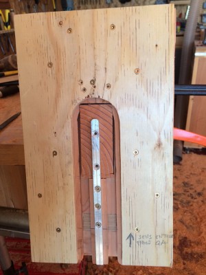 L'autre, c'est celui-ci. Il est un poil plus compliquÃ©, bien que le principe soit simple. En gros, le tenon aura l'Ã©paisseur de la barre d'alu + la diffÃ©rence entre le diamÃ¨tre de la fraise et celui de la bague. <br /><br />La plaque de cp est lÃ  pour l'appui de la semelle de dÃ©fonceuse et le tout est tenu par un dessous en douglas de 5 cm d'Ã©pais, qui me permet aussi de fixer la barre d'alu. <br /><br />La piÃ¨ce Ã  usiner, dont on distingue les cernes et la couleur plus rouge sur la photo, vient s'emboÃ®ter dans la gabarit, dans une lumiÃ¨re juste Ã  sa taille (+/- ;-))